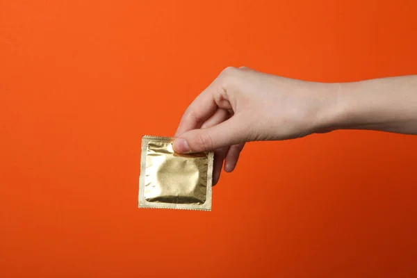 Sealed Condom Hand Orange Background — Stock Photo, Image