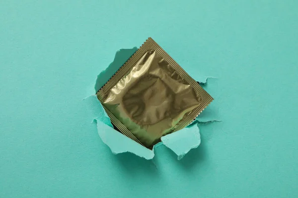 Condom Background Torn Turquoise Paper — Stock Photo, Image