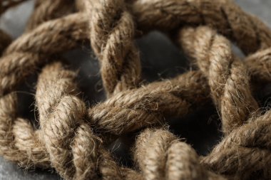 Gri arkaplanda kalın düğümlü ip yakın plan