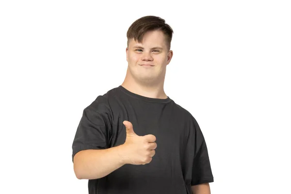 Png 黒いTシャツのダウン症候群を持つ微笑む若い男性が親指を示し 白い背景に隔離された — ストック写真