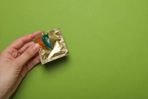 Open Package Condom Hand Green Background Place Text — Stock Photo, Image