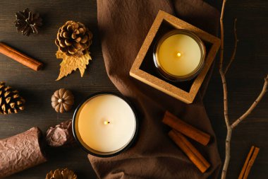 Havluda mumlar, tarçın ve tahta arka planda koniler, üst manzara.