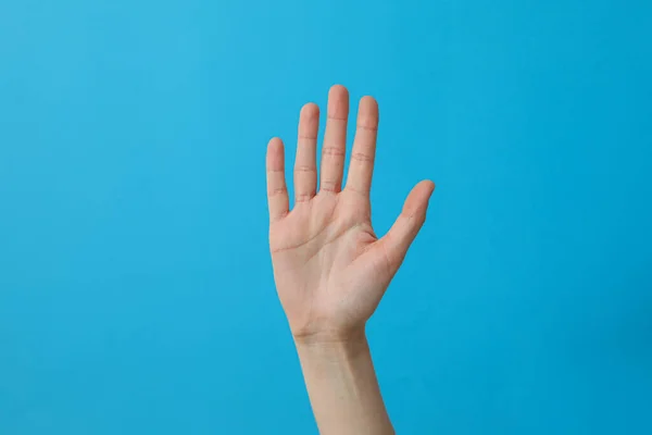 女性的手 蓝色背景上有五个手指 — 图库照片