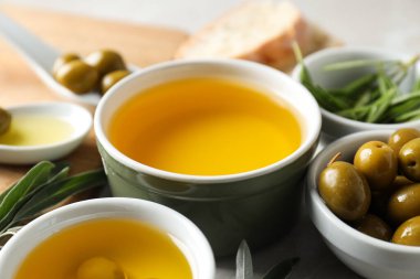 Beyaz arka planda zeytinyağı ve zeytinyağlı kaseler, yakın plan