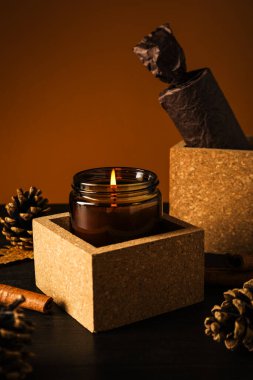 Mum tezgahta ve koniler kahverengi arkaplanda