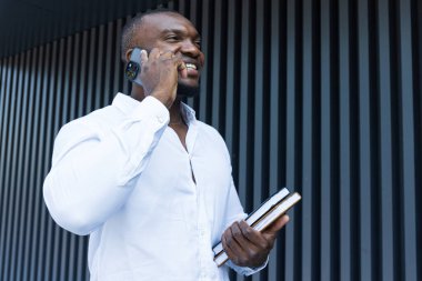 Elinde not defteri ve akıllı telefonu olan başarılı bir Afro-Amerikan.