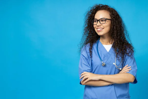 안경에 매력적인 소녀와 파란색 배경에 간호사의 유니폼 — 스톡 사진