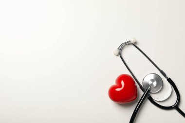 Red heart with a stethoscope on a white background. Blood donation, place for text clipart