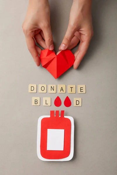 Бумажный Контейнер Кровью Руке Красным Сердцем Сером Фоне Донорство Крови — стоковое фото