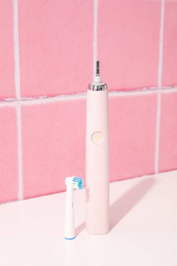 Pembe arka plandaki masada elektrikli diş fırçası