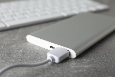 Gri arka planda kablosu olan Powerbank, kapat