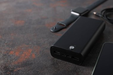Koyu gri arkaplanda Powerbank ve akıllı saat, kapatın