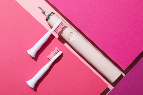 ピンクの背景に電気歯ブラシ トップビュー — ストック写真