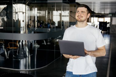 Neşeli genç bir girişimci modern bir çalışma alanında çalışır.