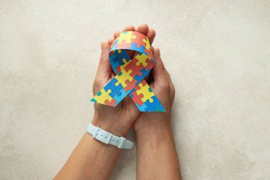 Açık arkaplanda çok renkli bulmacaları olan bir kurdele. Dünya otizm günü konsepti