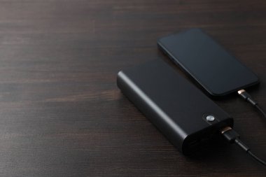 Tahta arkaplanda Powerbank ve smartphone, metin için boşluk
