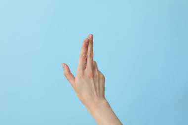 Açık mavi arka planda bakımlı bir kadın.