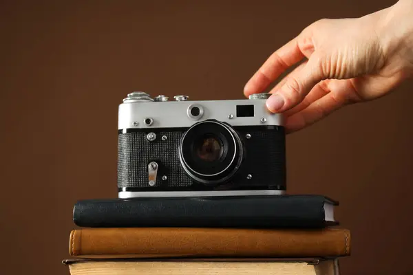 Vintage Kamera Auf Notizblöcken Und Weibliche Hand Auf Braunem Hintergrund — Stockfoto