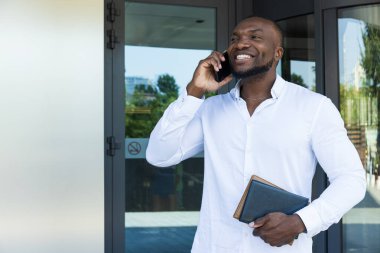 Elinde not defteri ve akıllı telefonu olan başarılı bir Afro-Amerikan.