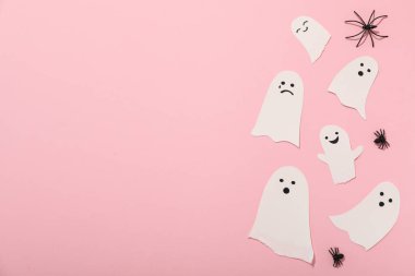 Dekoratif örümcekler ve kağıt hayaletler pembe arka planda, metin için boşluk