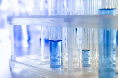 Beyaz zemin üzerinde sıvı bulunan cam test tüpleri, kapatın.