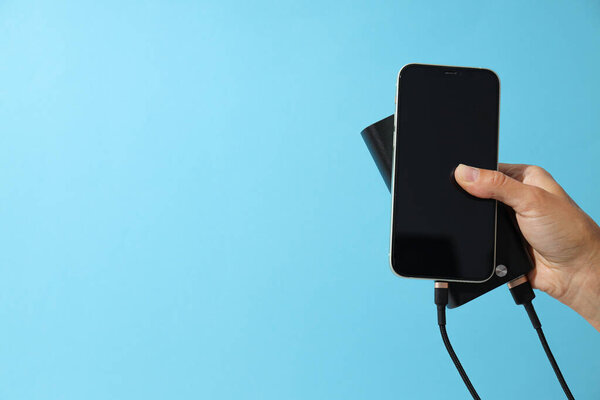 Powerbank и смартфон на синем фоне, место для текста