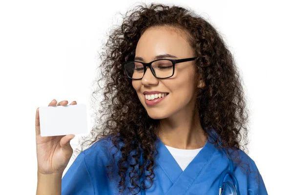 一个穿着蓝色护士制服的女孩 带着一张空白的纸 背景是白色的 — 图库照片