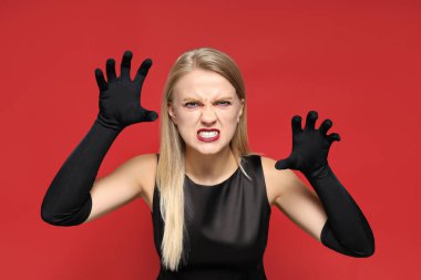 Cadılar bayramı vesilesiyle kırmızı arka planda zombi kostümü giymiş genç bir kız..