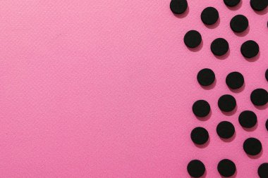 Pembe arkaplanda aktif kömür tabletleri