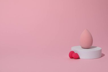Pembe arkaplanda kozmetik süngerler, metin için boşluk