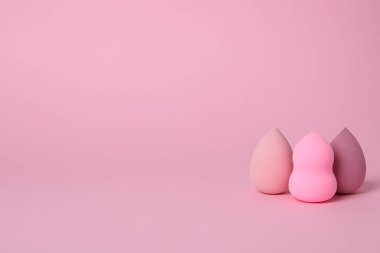 Pembe arkaplanda kozmetik süngerler, metin için boşluk