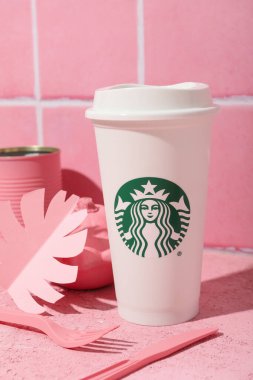 Ukrayna, Kyiv, 24 / 08 / 2023: Pembe arka planda bir fincan Starbucks kahvesi.