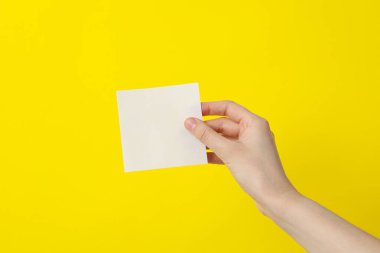 Bir kadının elinde beyaz, boş bir kağıt parçası.