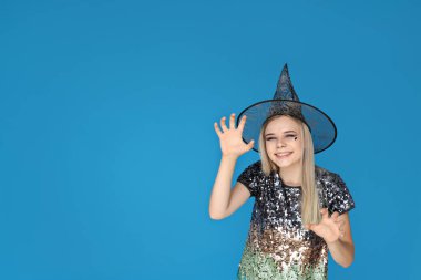 Cadılar Bayramı kostümlü bir kız mavi arka planda bir partide dans ediyor.