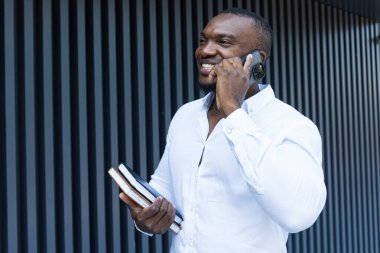 Elinde not defteri ve akıllı telefonu olan başarılı bir Afro-Amerikan.