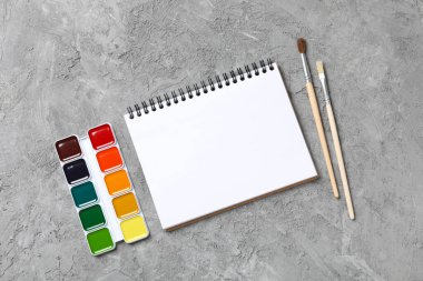 Gri arkaplanda not ve boyalar, üst görünümde