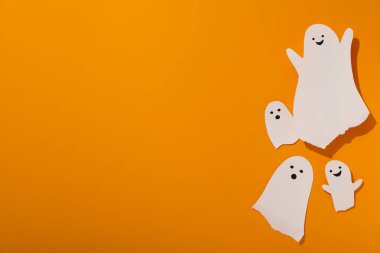 Turuncu arkaplanda kağıt hayaletler, metin için boşluk