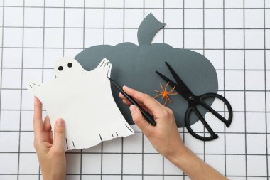 Makas, kağıt balkabağı ve hayalet kadın ellerinde ışık arka planda, üst manzara