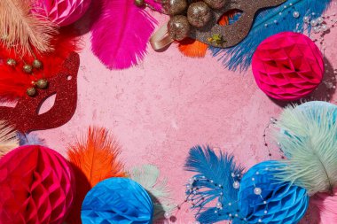 Pembe arka planda karnaval maskeleri ve tüyleri, metin için boşluk