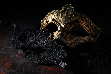 Karnaval maskeleri ve tüyleri koyu arkaplanda, yakın plan