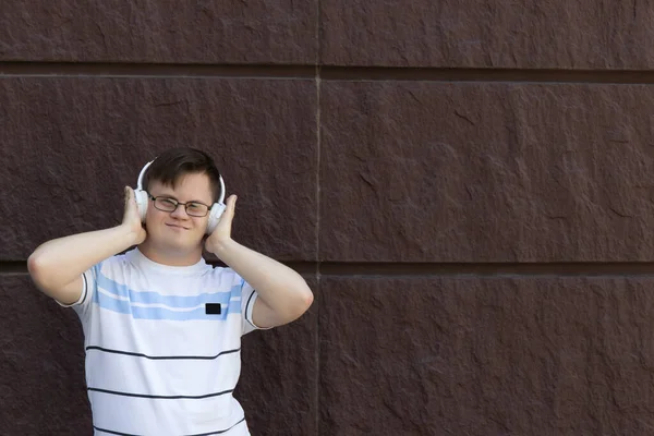 Gözlüklü Gülümseyen Genç Adam Kulaklıkla Müzik Dinliyor Mesaj Yazıyor — Stok fotoğraf