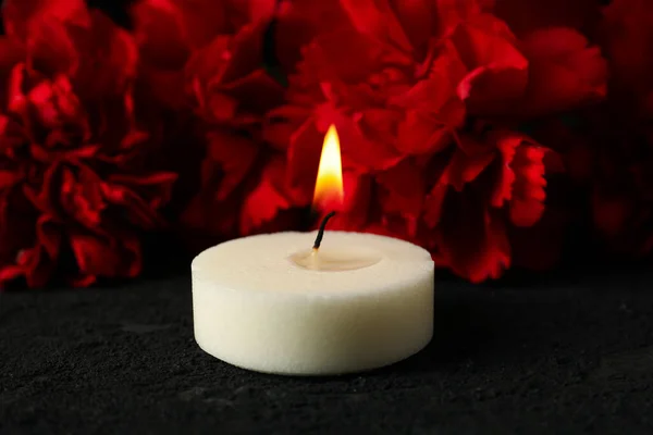 黑色背景上的花朵和燃烧的蜡烛 — 图库照片