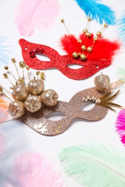 Beyaz arka planda karnaval maskeleri ve tüyleri