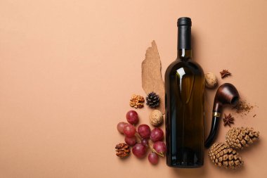 Bej arka planda cam şişe, üzüm ve koni, metin için boşluk