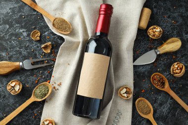 Havlu üzerindeki cam şişe ve arka plandaki baharatlı ahşap kaşıklar.