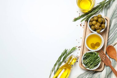 Kâselerde zeytin dalları, yağ ve zeytin, beyaz arka planda havlu, metin için yer