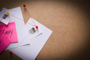 Kağıtlar tahtadaki ipliklerle bağlantılı.