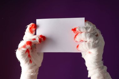 Bandaja sarılı eller boş bir kağıt parçası tutuyor.