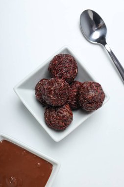Beyaz arka planda kaselerde Brigadeiro ve çikolata, üst manzara