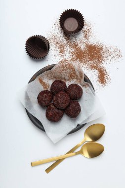 Tabakta Brigadeiro ve beyaz arka planda altın kaşıklar, üst manzara